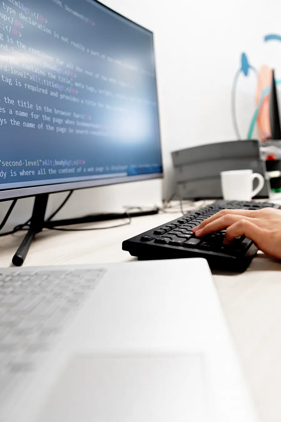 Developer typing with code up on a monitor