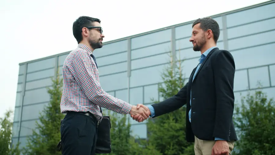 Two professionals closing a deal with a handshake